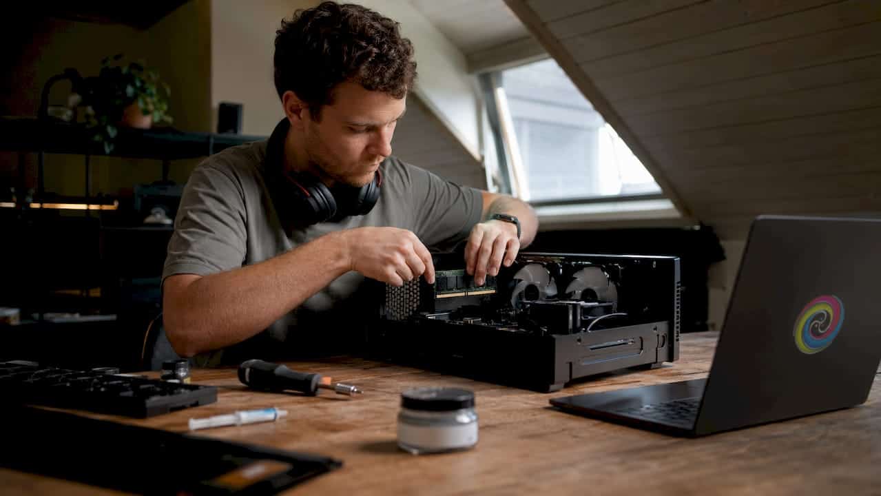 Een man is achter zijn bureau bezig om de hardware van zijn gaming-pc te optimaliseren.