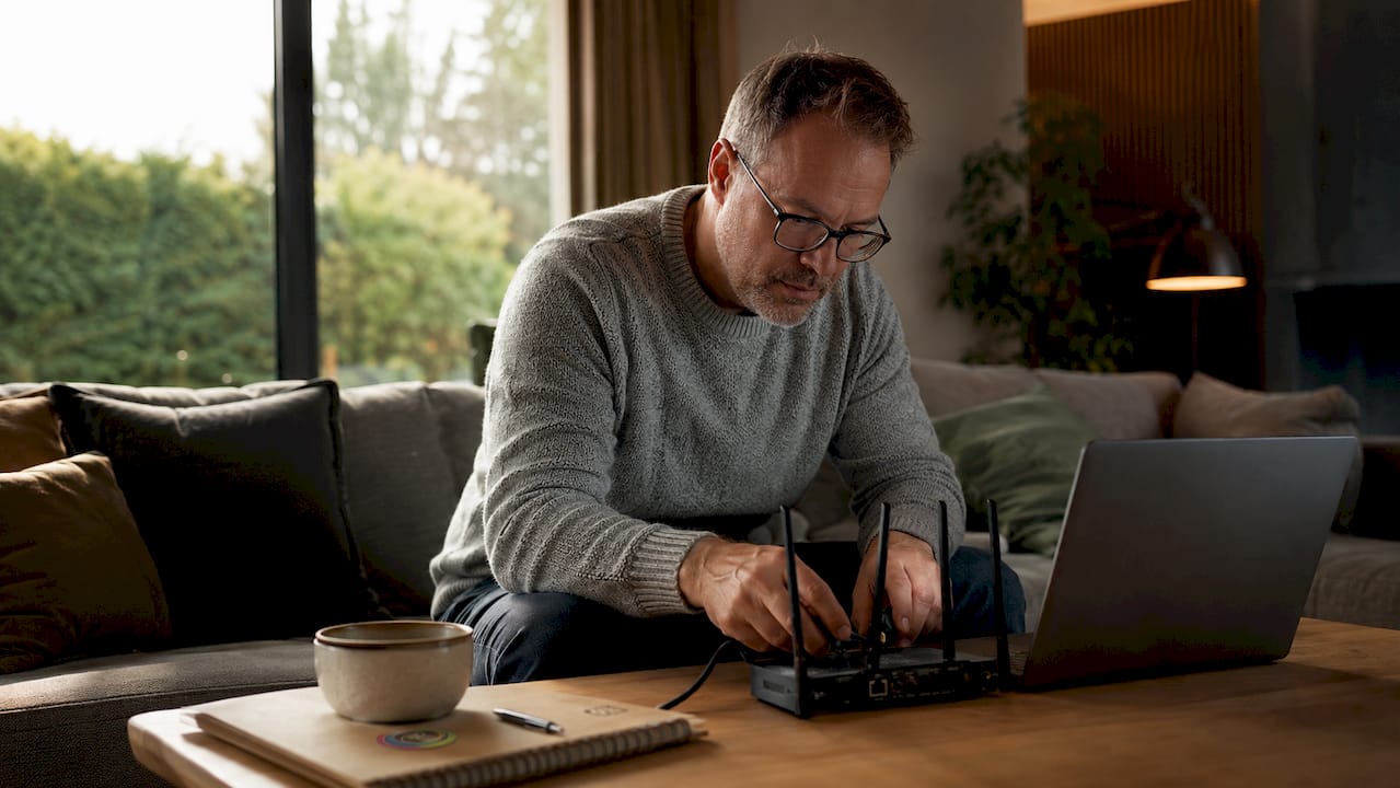 Man voert firmware-update uit terwijl hij aan de keukentafel zit